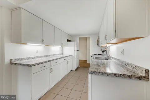 a kitchen with granite countertop a sink and a stove