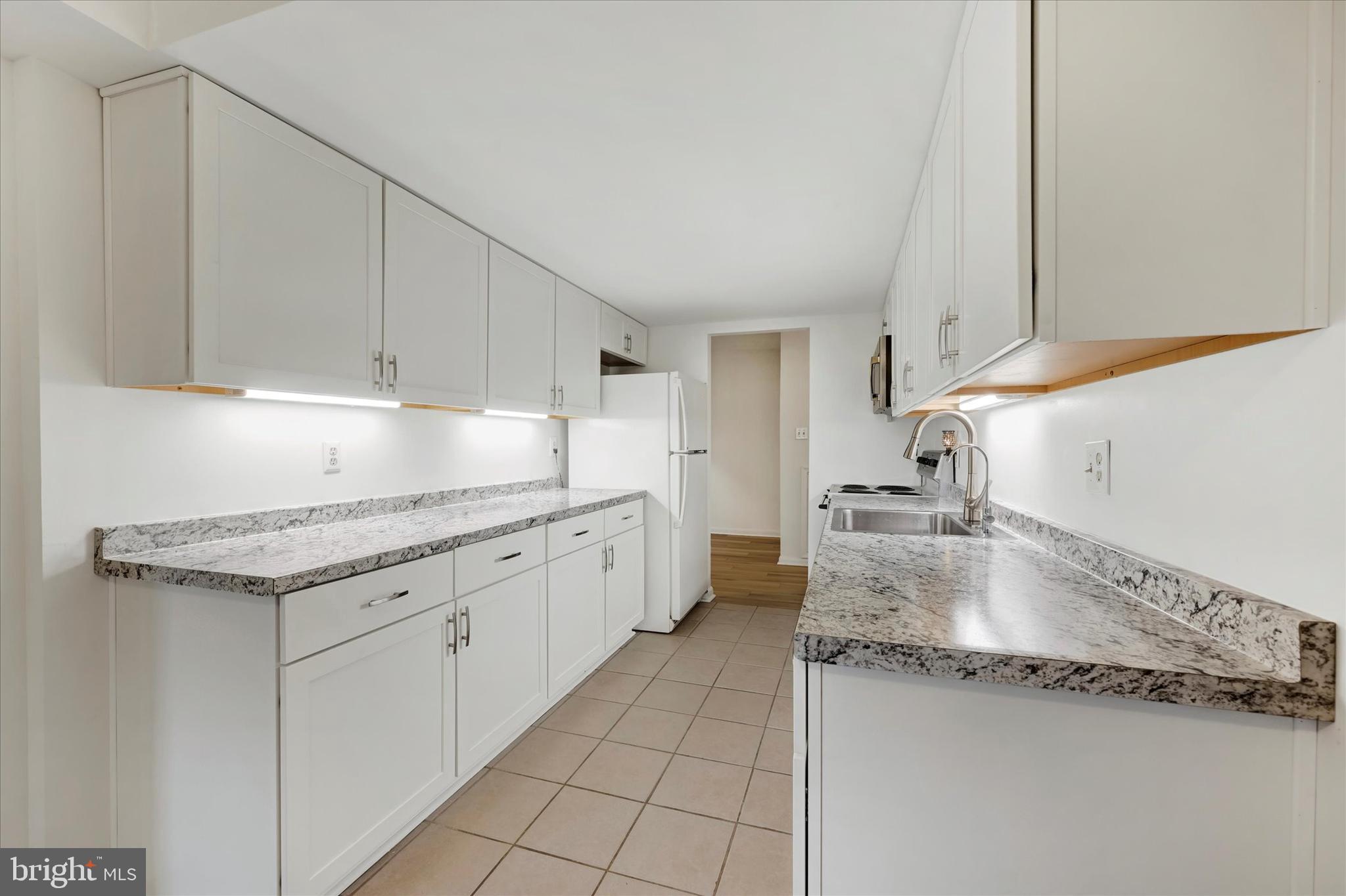 13139 Dairymaid Drive, Unit 99/T1 Germantown, MD 20874 - Photo 6 of 17 a kitchen with granite countertop a sink and a stove