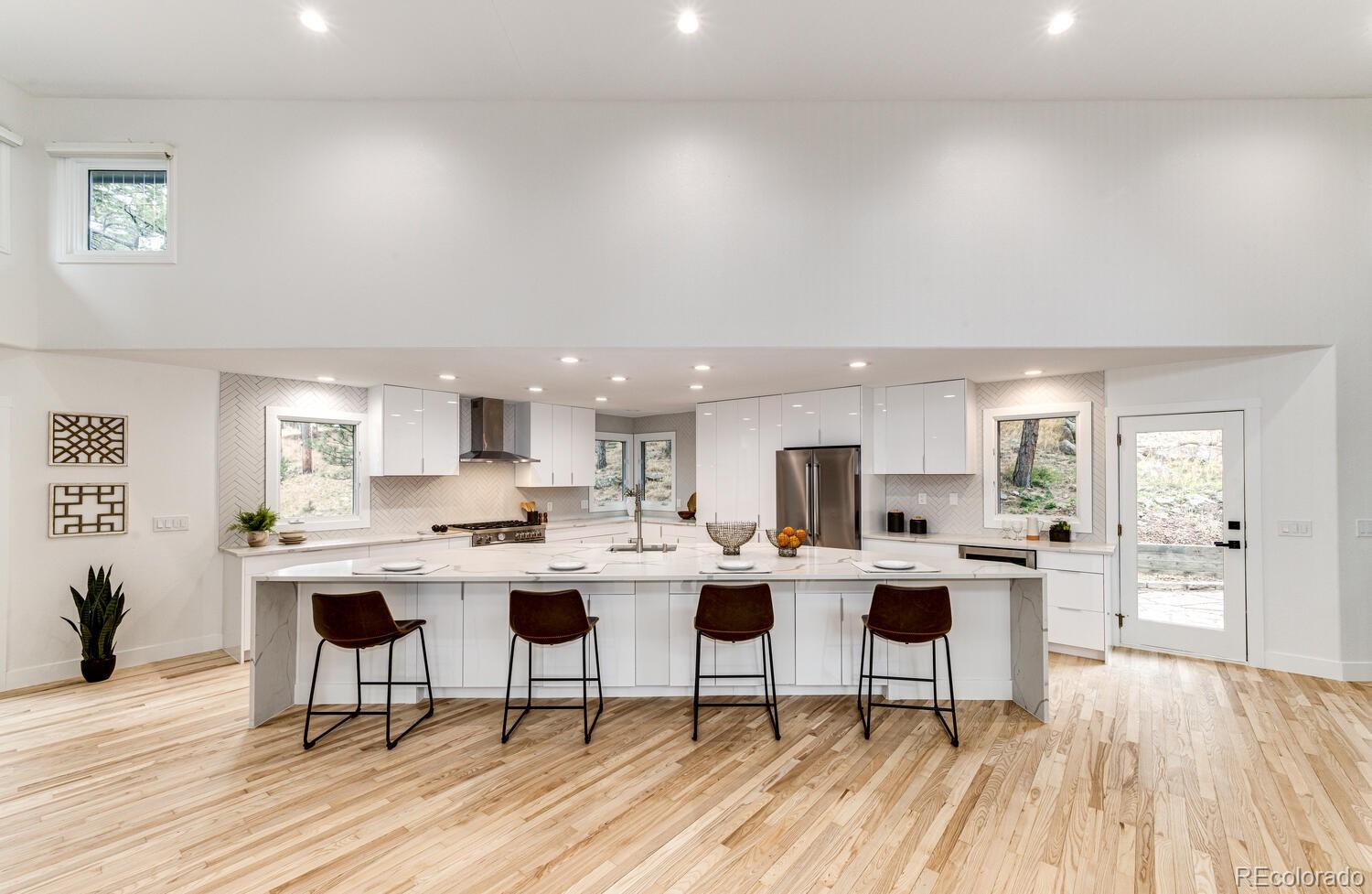 a open kitchen with a dining table chairs and white appliances