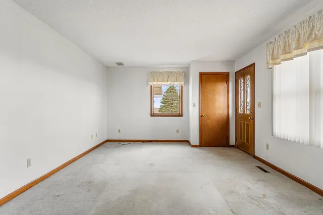 an empty room with windows and closet