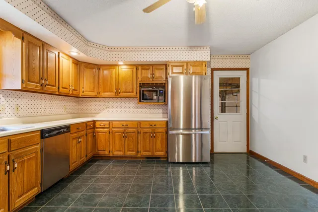 a kitchen with stainless steel appliances granite countertop a refrigerator a sink and dishwasher