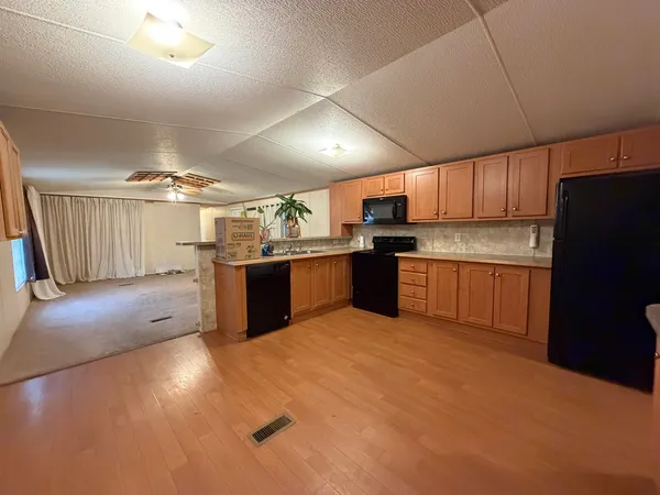 a kitchen with stainless steel appliances granite countertop a refrigerator oven a sink dishwasher and a stove top oven