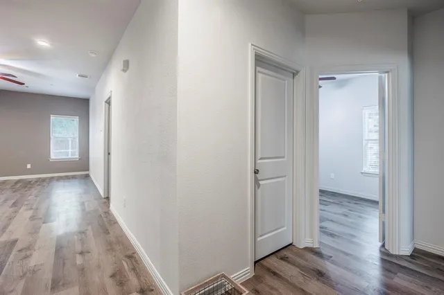 a view of a hallway with wooden floor