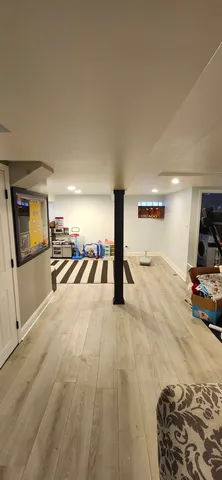 a living room with couches rug and kitchen view