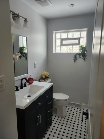 a bathroom with a sink toilet and window
