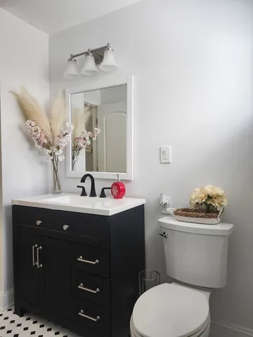 a bathroom with a toilet a sink and mirror
