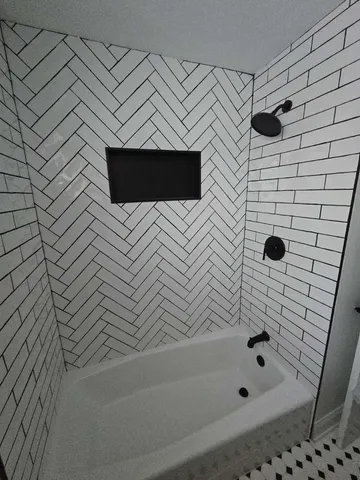 a bathroom with a bathtub and shower