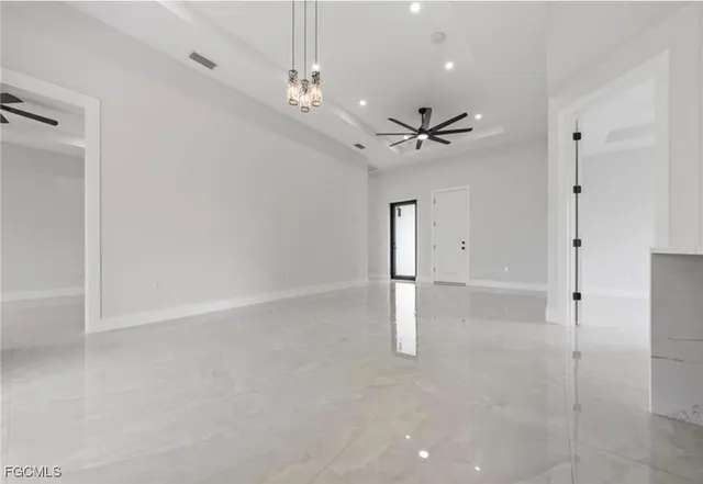 en empty room with ceiling fan and window