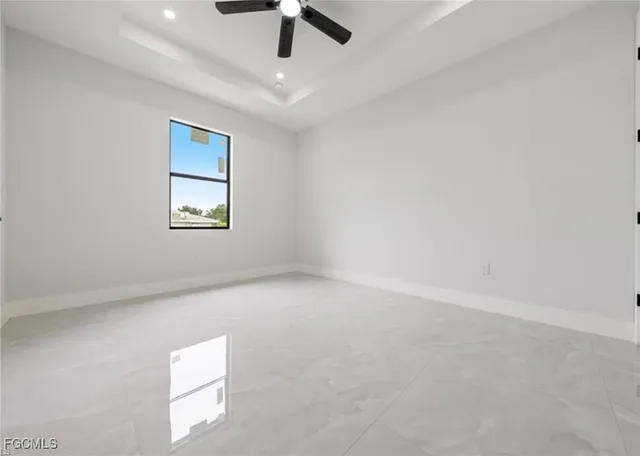 en empty room with ceiling fan and window