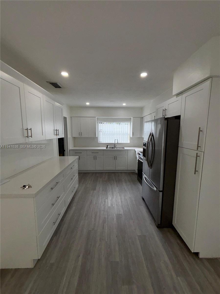 11105 Southwest 156th Terrace Miami, FL 33157 - Photo 15 of 23 a kitchen with refrigerator cabinets and wooden floor