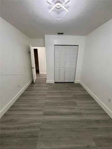 a kitchen with refrigerator cabinets and wooden floor