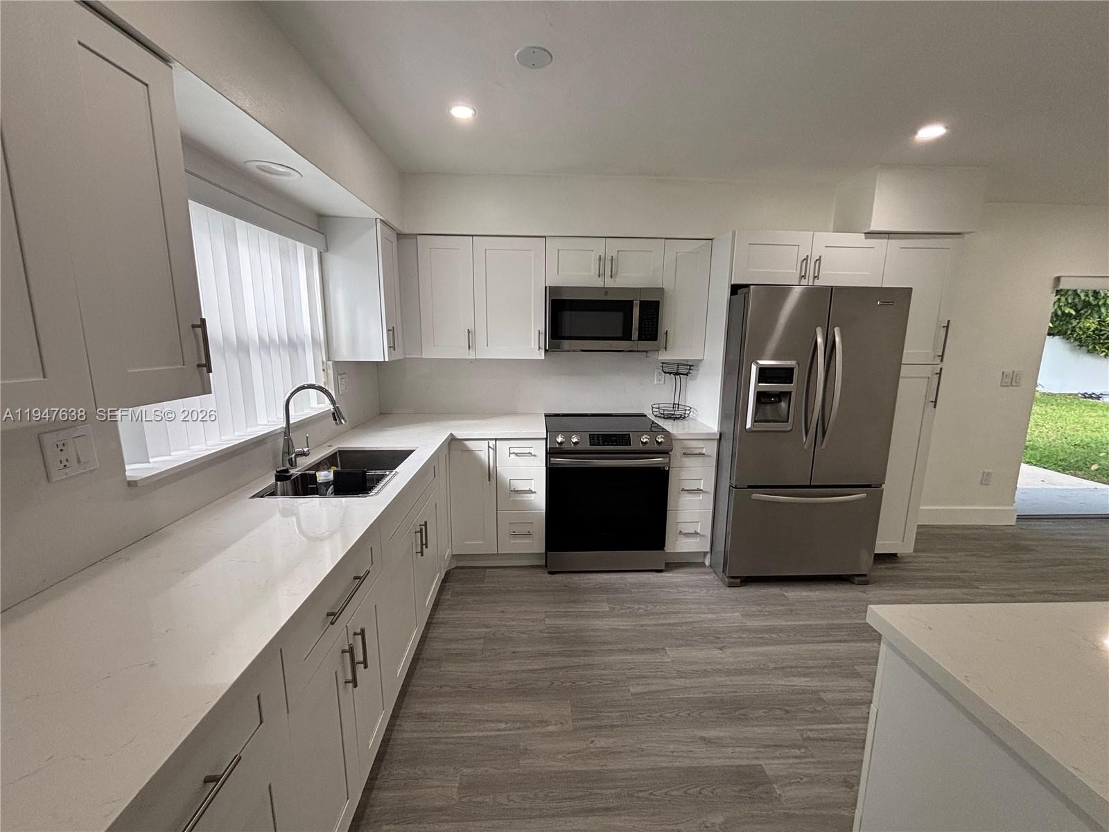 11105 Southwest 156th Terrace Miami, FL 33157 - Photo 2 of 23 a large kitchen with stainless steel appliances granite countertop a sink a stove and a refrigerator