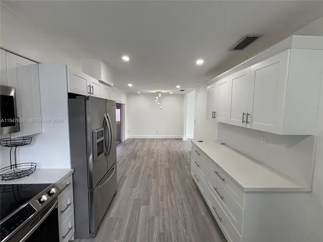 a kitchen with a refrigerator and a stove top oven