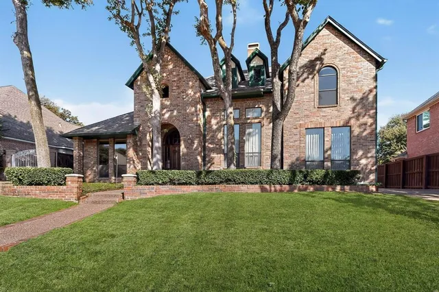 a front view of a building with large trees