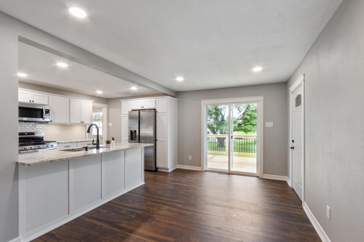 2072 Highway 26 Dixon, IL 61021 - Photo 12 of 30 a kitchen with stainless steel appliances granite countertop a stove top oven a sink dishwasher a refrigerator and white cabinets with wooden floor
