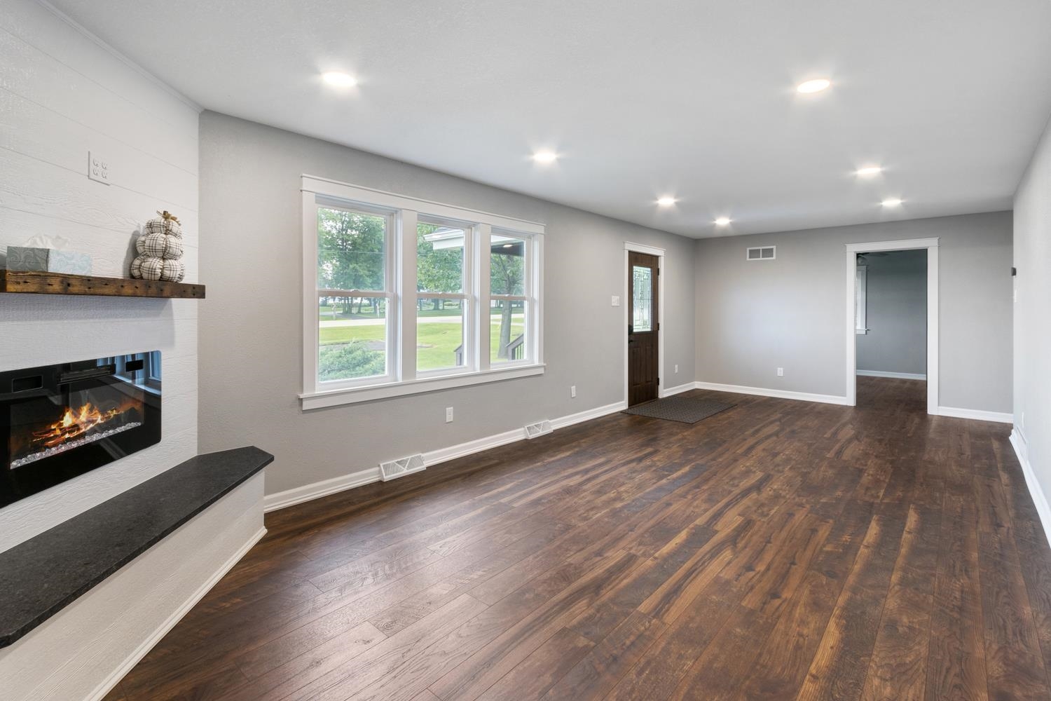 2072 Highway 26 Dixon, IL 61021 - Photo 8 of 30 a view of an empty room with wooden floor fireplace and a window