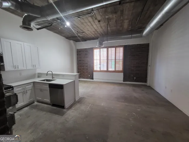 a view of an empty room with a kitchen