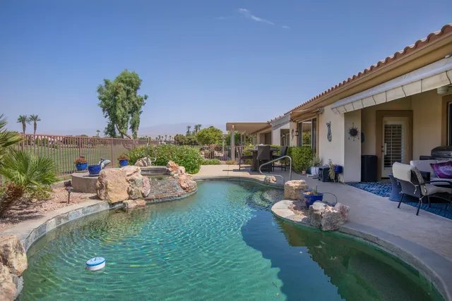 a view of a swimming pool with lounge chairs in patio