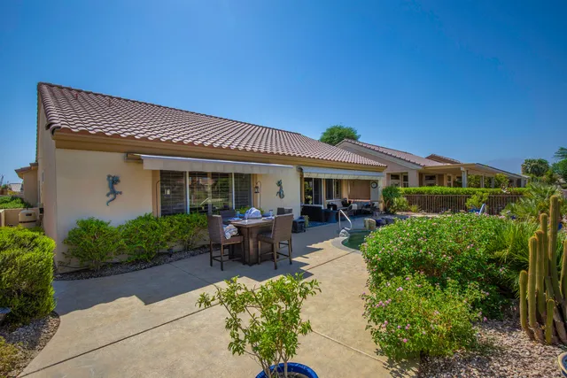 a view of a house with sitting area and garden