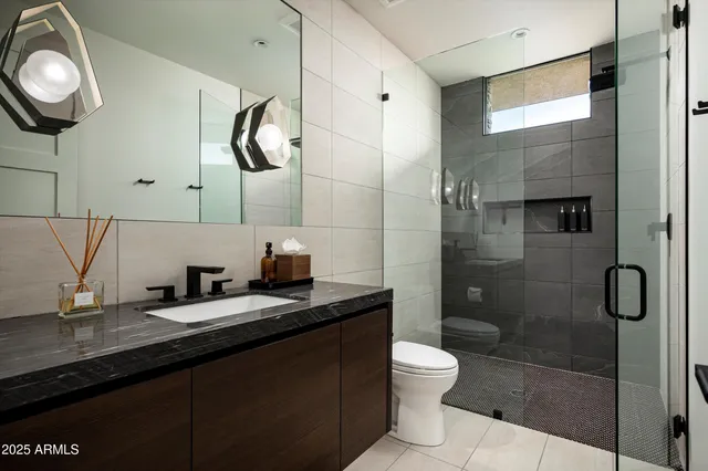 a bathroom with a granite countertop sink toilet and shower