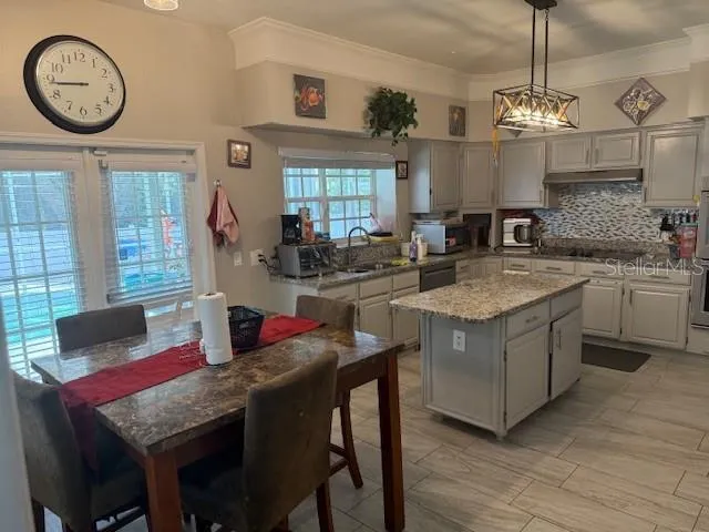 a kitchen with a table chairs a stove a window and cabinets
