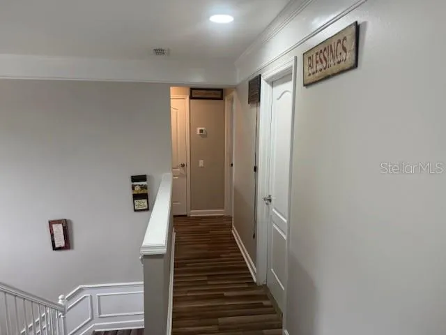 a view of a hallway with wooden floor and entryway