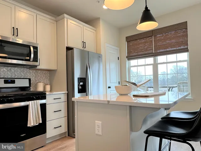a kitchen with stainless steel appliances a stove a sink and a refrigerator