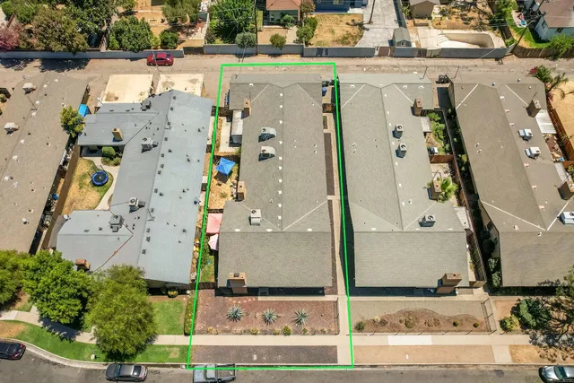an aerial view of a residential apartment building with a street