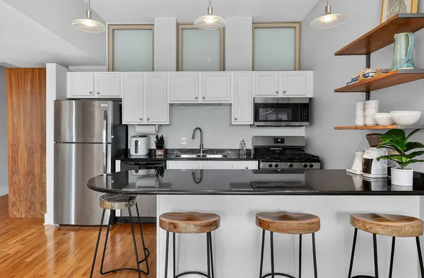 a kitchen with stainless steel appliances granite countertop a sink a stove and a refrigerator