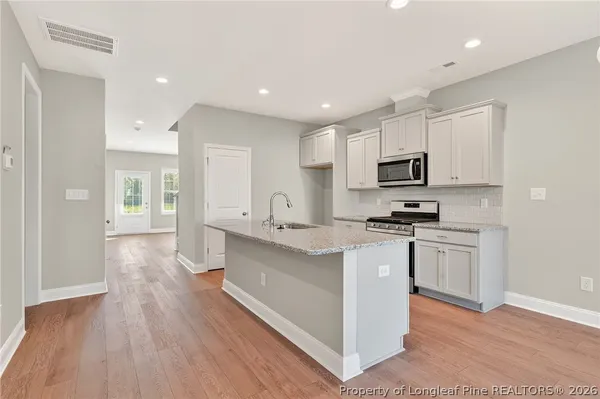 a kitchen with white cabinets and appliances