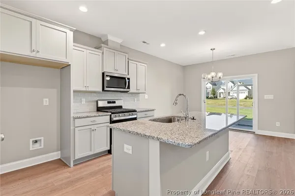 a kitchen with granite countertop kitchen island wooden cabinets and stainless steel appliances