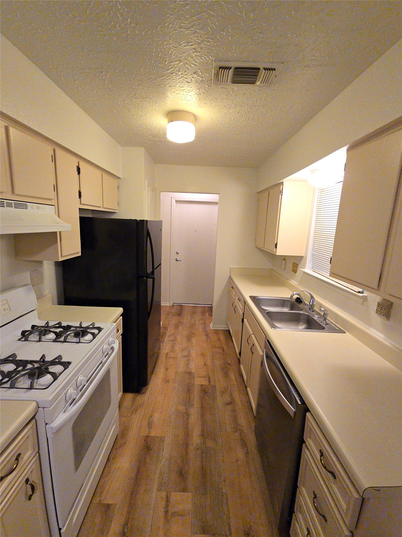 10906 Maple Rock Drive Humble, TX 77396 - Photo 14 of 27 a kitchen with a stove and a refrigerator