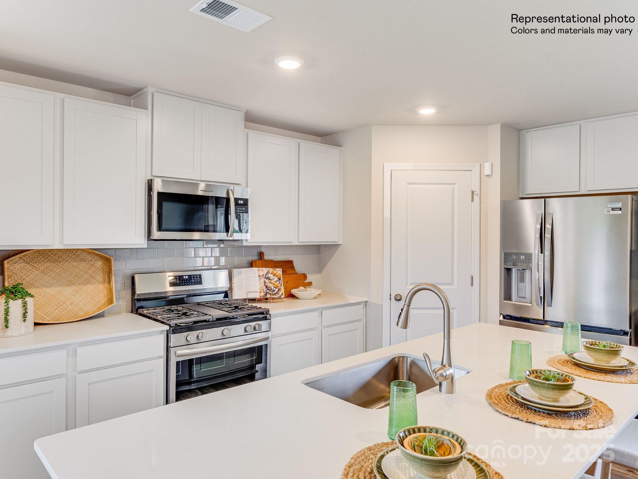1623 Spring Edgemoor Sc 29712 Edgemoor, SC 29712 - Photo 11 of 30 a kitchen with sink a stove and white cabinets with wooden floor