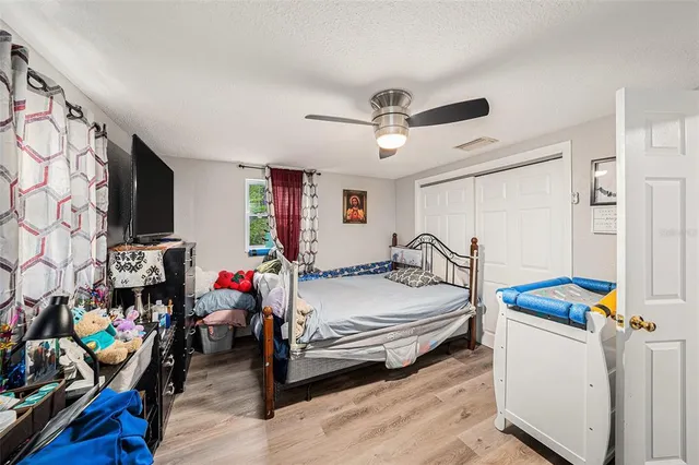 a bedroom with bed and wooden floor