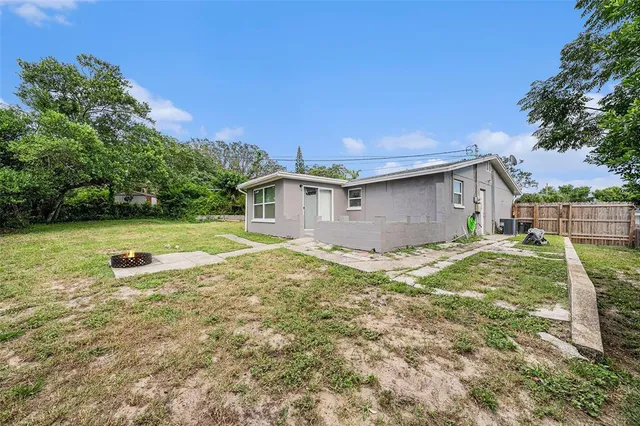 a view of a house with backyard and sitting area