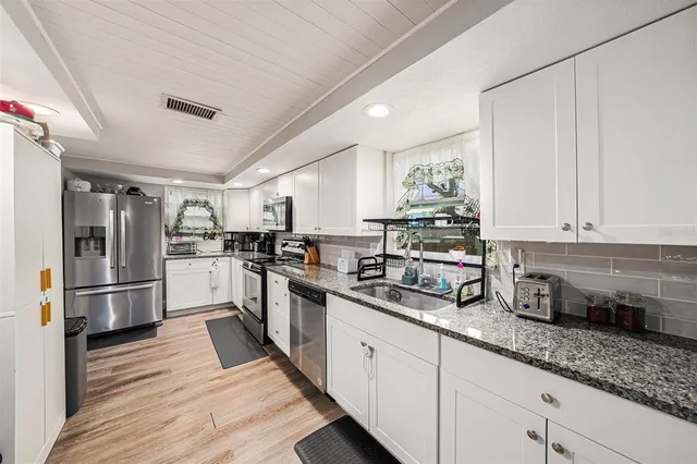 a kitchen with refrigerator and cabinets