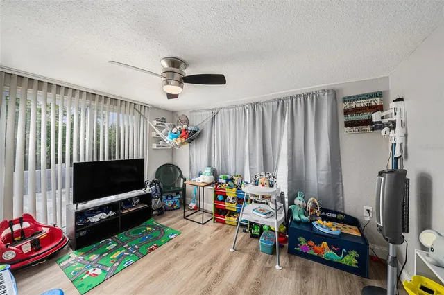 a living room with furniture a flat screen tv and a window