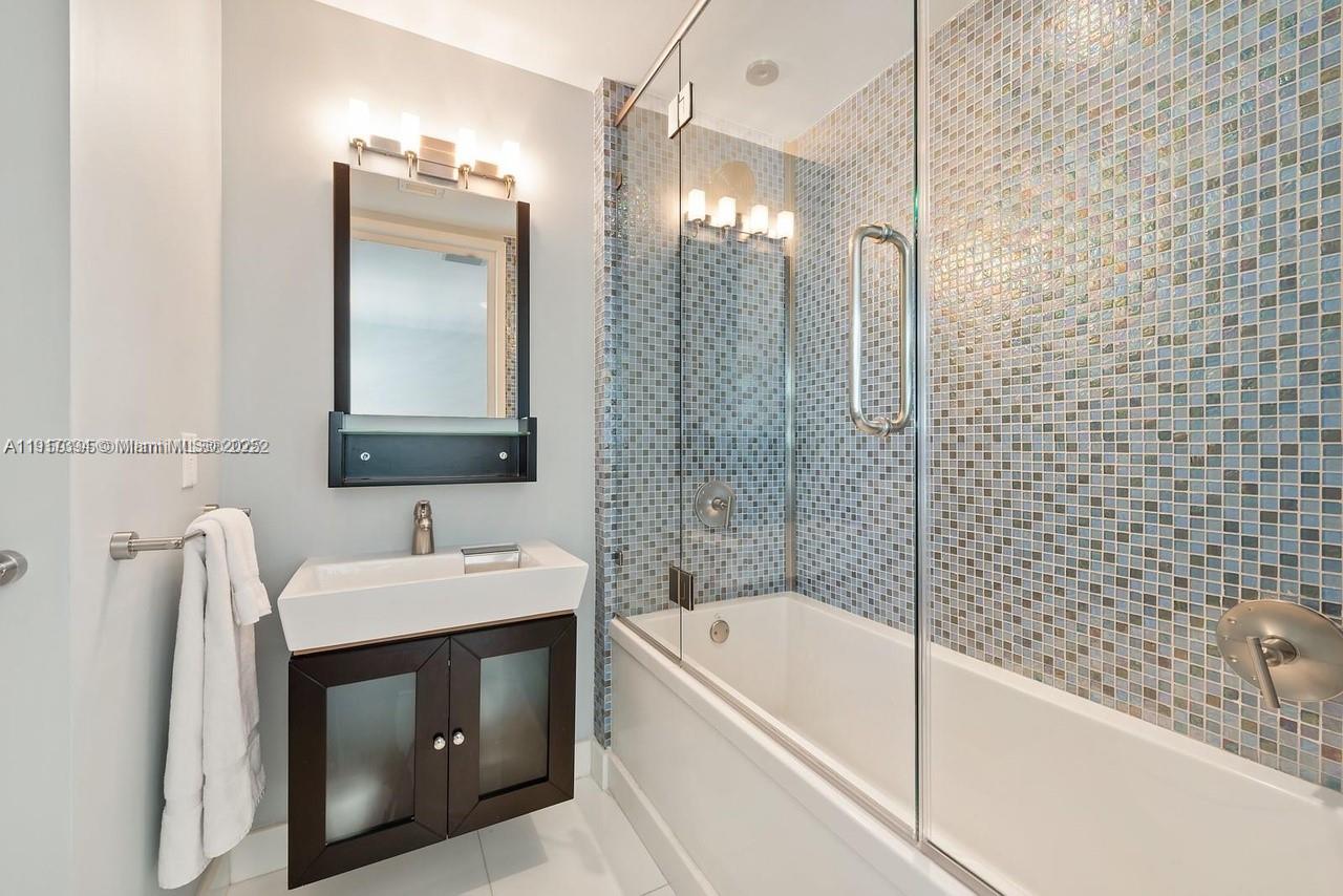 1040 Biscayne Boulevard, Unit 4403 Miami, FL 33132 - Photo 10 of 31 a bathroom with a tub sink and mirror