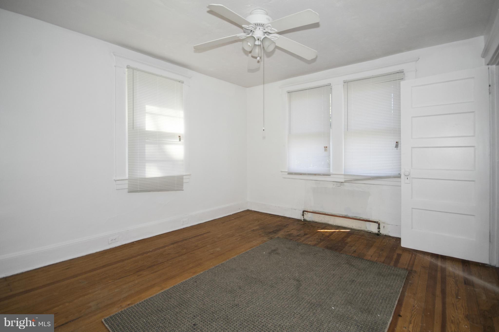 1803 Chelsea Road Baltimore, MD 21216 - Photo 21 of 30 wooden floor in an empty room with a window