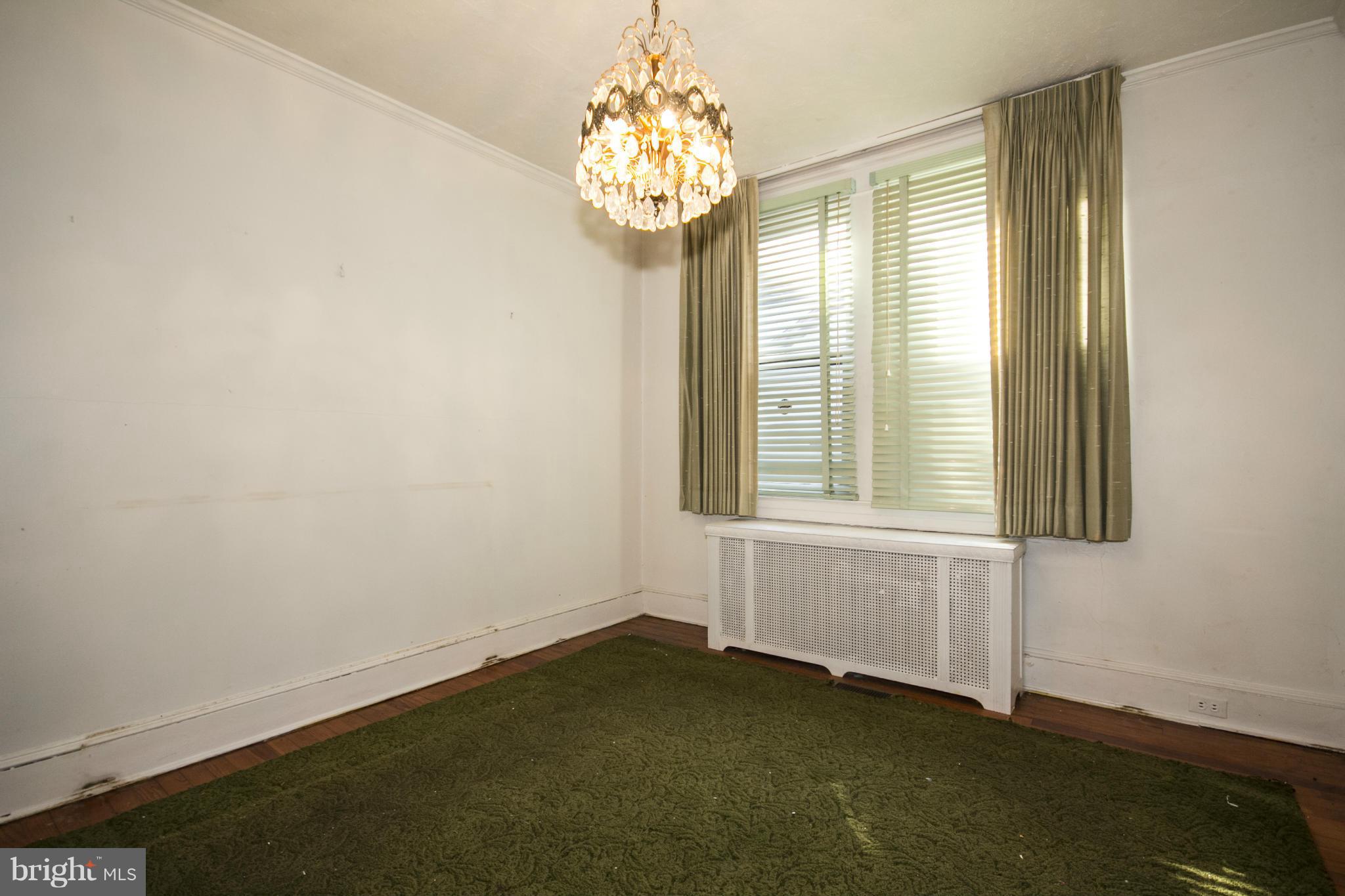 1803 Chelsea Road Baltimore, MD 21216 - Photo 7 of 30 an empty room with windows and chandelier