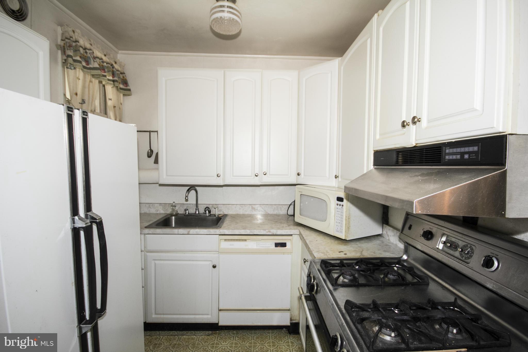 1803 Chelsea Road Baltimore, MD 21216 - Photo 10 of 30 a kitchen with a stove and a refrigerator
