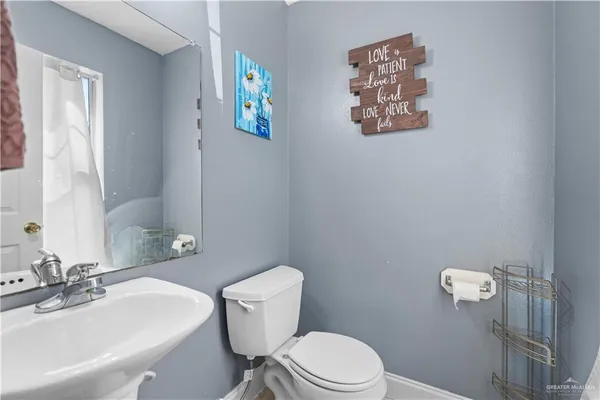 a bathroom with a toilet a sink and mirror