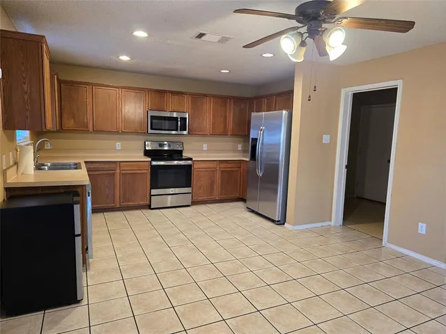 a kitchen with granite countertop a stove sink and cabinets