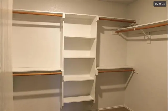 a view of walk in closet with empty racks