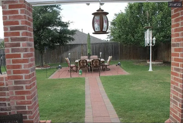 a view of a chair and table in backyard of the house