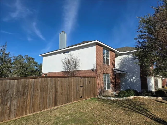 a view of a house with a wooden fence