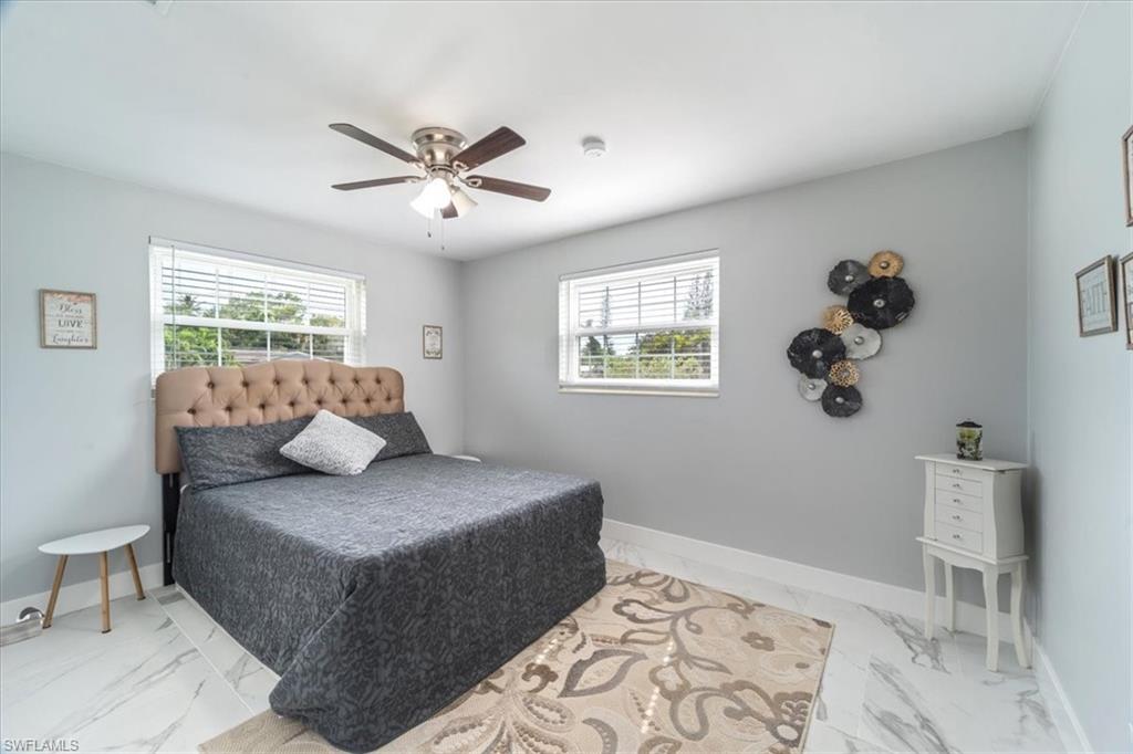 3999 Guava Drive Naples, FL 34104 - Photo 14 of 24 a bedroom with a large bed and a couch