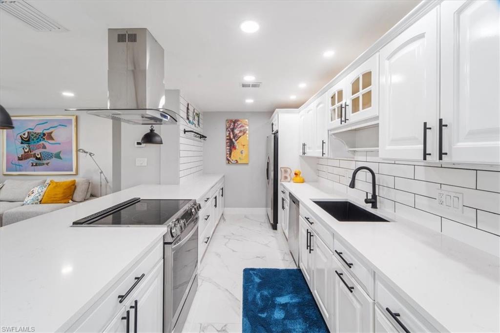 3999 Guava Drive Naples, FL 34104 - Photo 2 of 24 a kitchen with stainless steel appliances a sink a stove and a refrigerator