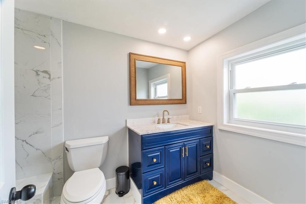 3999 Guava Drive Naples, FL 34104 - Photo 10 of 24 a bathroom with a toilet a sink and mirror