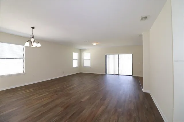 an empty room with wooden floor and window